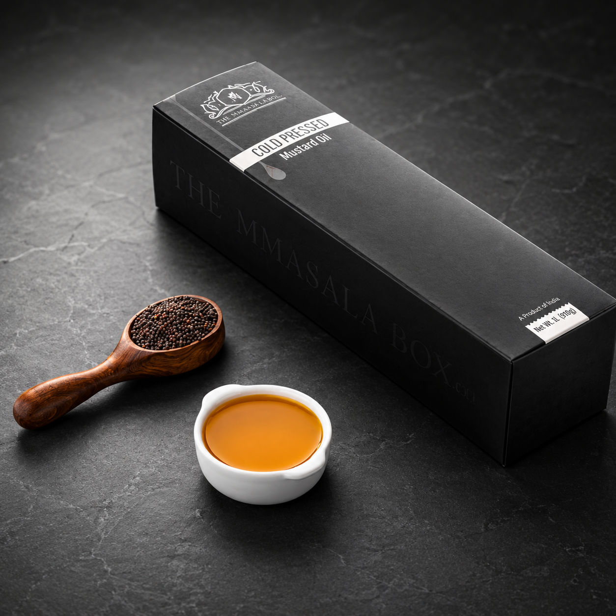 Premium cold pressed mustard oil packaging by The MMasala Box Co with mustard seeds and oil bowl on a dark luxury background.