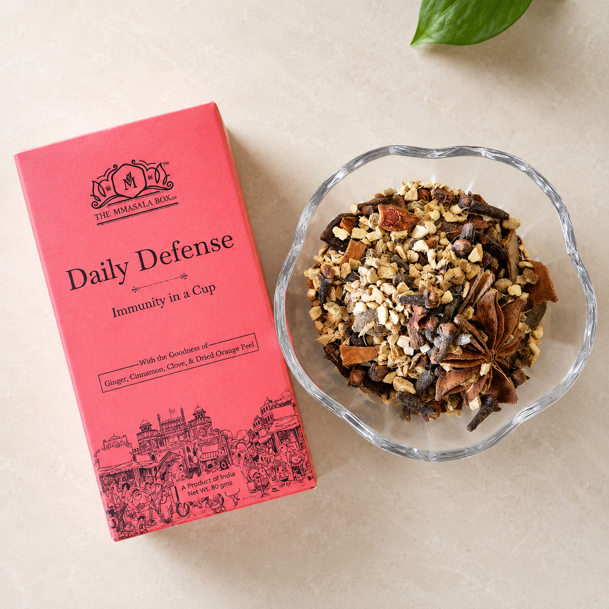 Daily Defense Immunity in a Cup product box with loose herbal blend ingredients including ginger, cinnamon, clove and dried orange peel in a glass bowl.