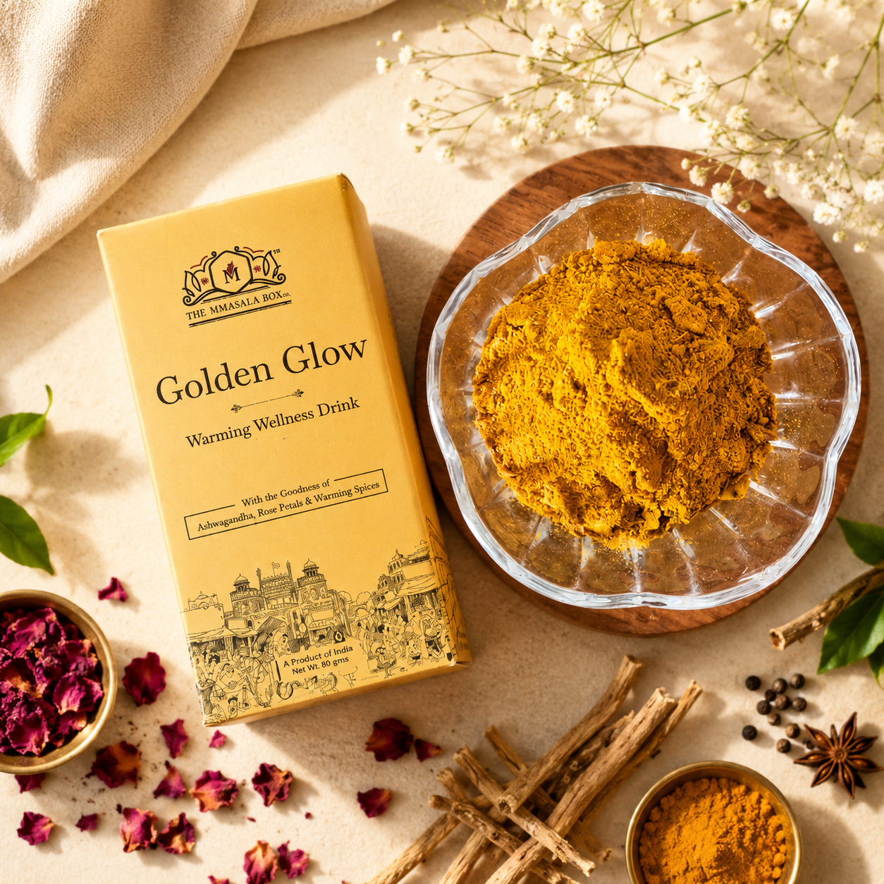 Golden Glow wellness drink by The Mmasala Box Co. displayed with a bowl of golden herbal powder, rose petals, and warming spices, highlighting natural wellness ingredients and comforting daily nourishment.