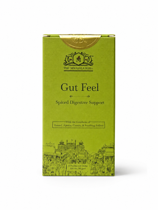 Woman holding Gut Feel Spiced Digestive Support wellness drink box with herbal tea, digestive spices, and wellness-focused product information by The Mmasala Box Co.
